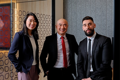 Three home lending executive stand together smiling.