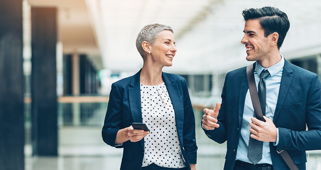 941286236 Two businesspersons walking together and talking