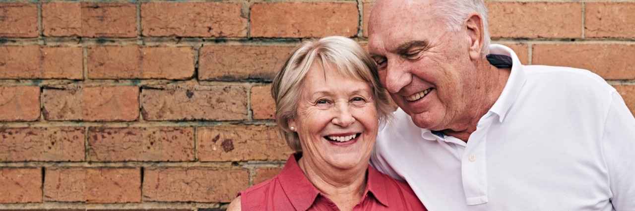 senior-couple-smiling-outside