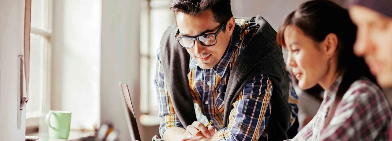 a man and woman looking at a laptop