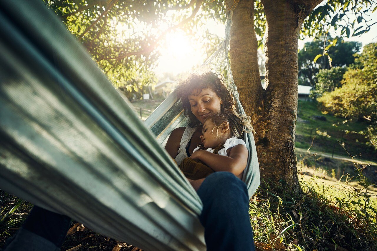 Shot of a mother cuddling her young daughter while they relax in a hammock