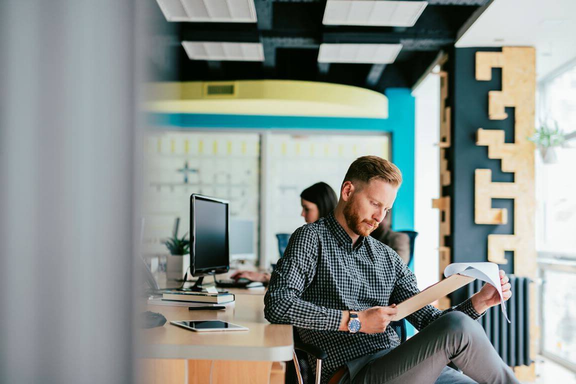 Caucasian businessman reading a file at his office.