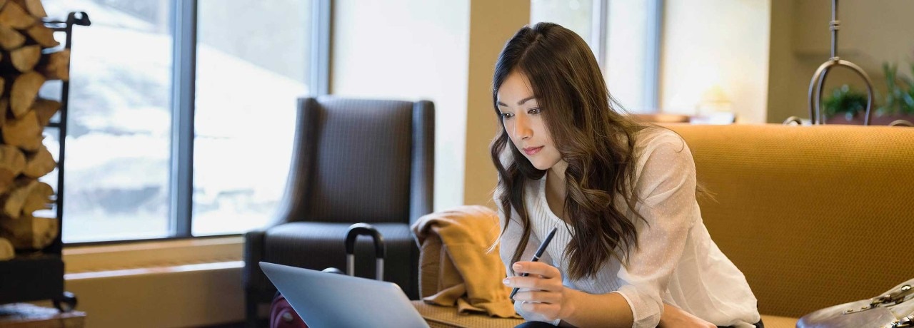 Businesswoman working at laptop in lobby