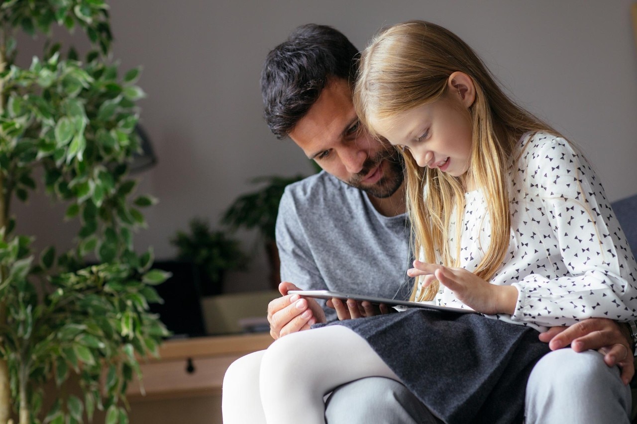 Father and Daughter Reading from Tablet Together